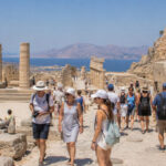 Internationale Touristen besichtigen eine historische Ausgrabungsstätte in Griechenland im Sommer
