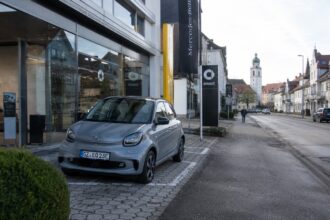 Μικρό αγόρι κοιτάζει ένα σταθμευμένο ηλεκτρικό αυτοκίνητο στη Βαυαρία.