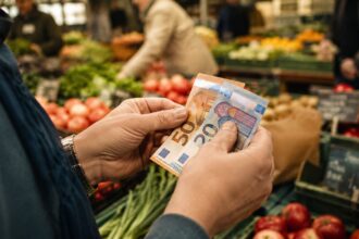 Γυναίκα στη Γερμανία μετράει χαρτονομίσματα ευρώ έχοντας ενισχυμένη αγοραστική δύναμη