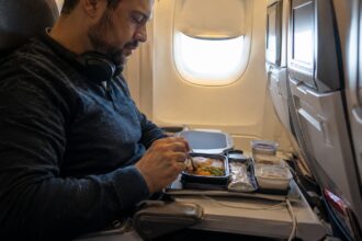 Γεύμα με ζεστό φαγητό σε δίσκο επιβάτη στην Economy Class κατά τη διάρκεια πτήσης