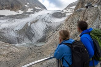 Λιώσιμο του παγετώνα στο βουνό Zugspitze στη Βαυαρία με σκούρα πετρώματα στην επιφάνεια του πάγου