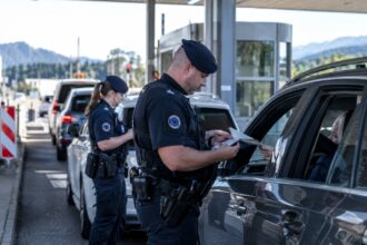 Ευρωπαίοι συνοριοφύλακες της Frontex ελέγχουν ταξιδιωτικά έγγραφα σε συνοριακό σταθμό.