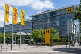 Κεντρικά γραφεία της DHL και της Deutsche Post στη Βόννη της Γερμανίας με τις χαρακτηριστικές σημαίες των δύο εταιρειών.