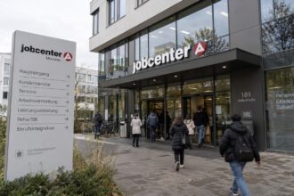Είσοδος ενός σύγχρονου κτιρίου Jobcenter στη Γερμανία με πολίτες να περιμένουν