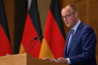 Ο Καγκελάριος της Γερμανίας Friedrich Merz μιλά σε βήμα συνεδρίου για την οικονομία και τις συντάξεις.