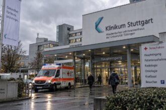 Σύγχρονο γερμανικό νοσοκομείο υπό συννεφιασμένο ουρανό, αναδεικνύοντας το κλίμα κρίσης