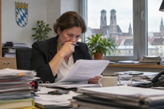 Δημοτικός υπάλληλος στη Βαυαρία ελέγχει έγγραφα προϋπολογισμού σε γραφείο.