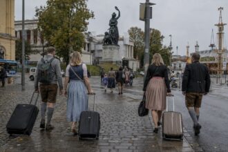 Τουρίστες με αποσκευές περπατούν στο Μόναχο κοντά στους χώρους του Oktoberfest