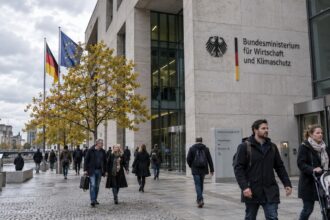 Ομοσπονδιακό κτίριο στο Βερολίνο με πολίτες να διέρχονται υπό φυσικό φως καθώς συζητούνται περικοπές επιδομάτων στη Γερμανία