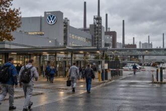 Εργοστάσιο της Volkswagen στη Γερμανία με εργαζομένους εν ώρα βάρδιας σε συννεφιασμένο τοπίο