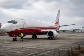 Φορτηγό Boeing 737 σταθμευμένο σε αεροδρόμιο με τεχνικό συντήρησης δίπλα του, σε συμβολική εικόνα.