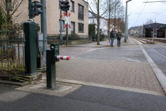Συμβολική απεικόνιση πολύ μικρής μπάρας δίπλα σε σιδηροτροχιές σε αστική περιοχή της Κολωνίας
